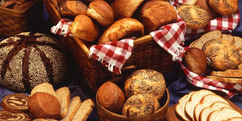 A selection of various breads elegantly arranged on a table, showcasing different shapes and textures